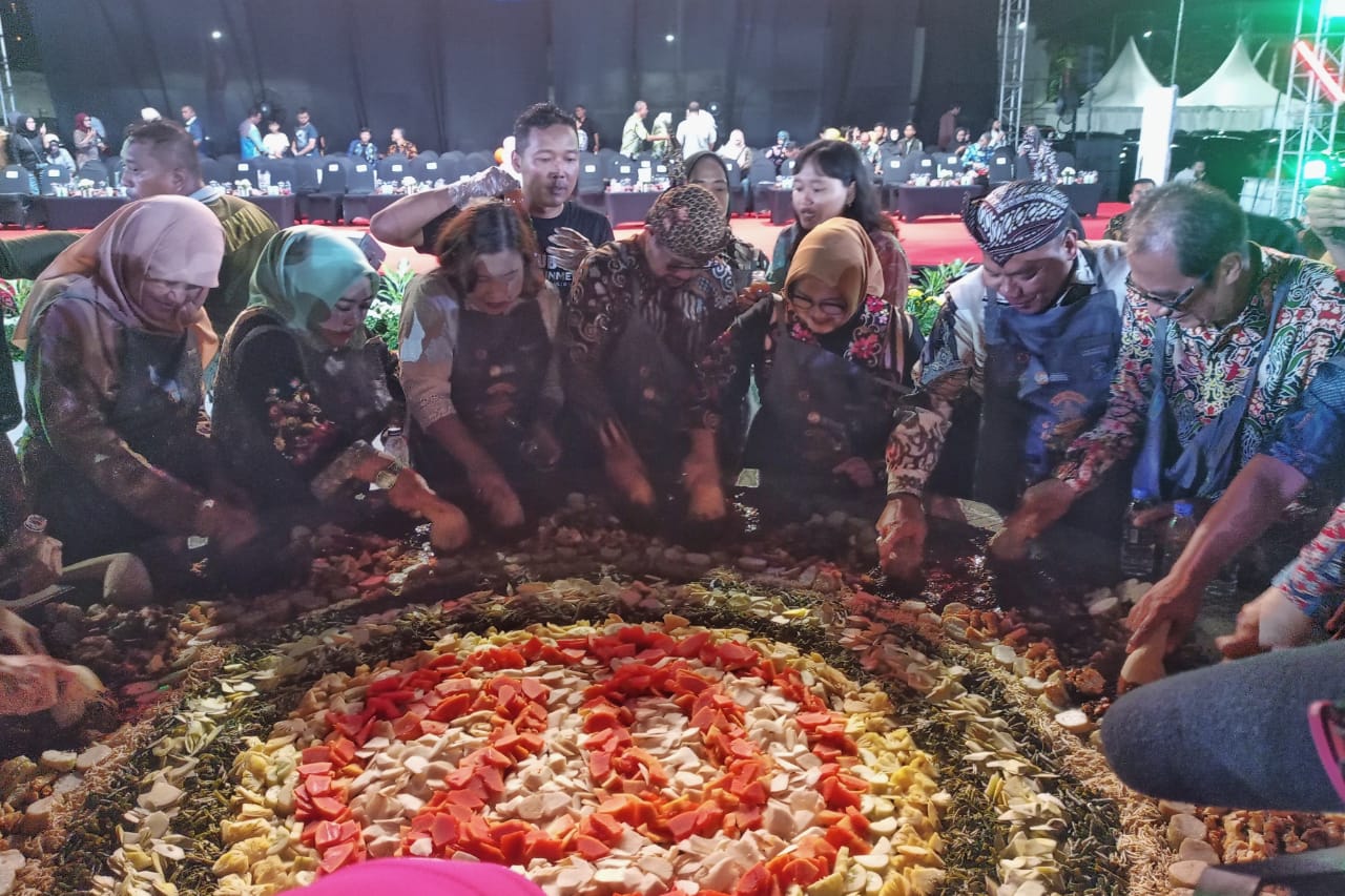 MERIAH: Para tamu kehormatan dan peserta melakukan aksi menguleg bersama di cobek raksasa yang menjadi ikon utama festival. (SURYANTO/RADAR SIDOARJO)