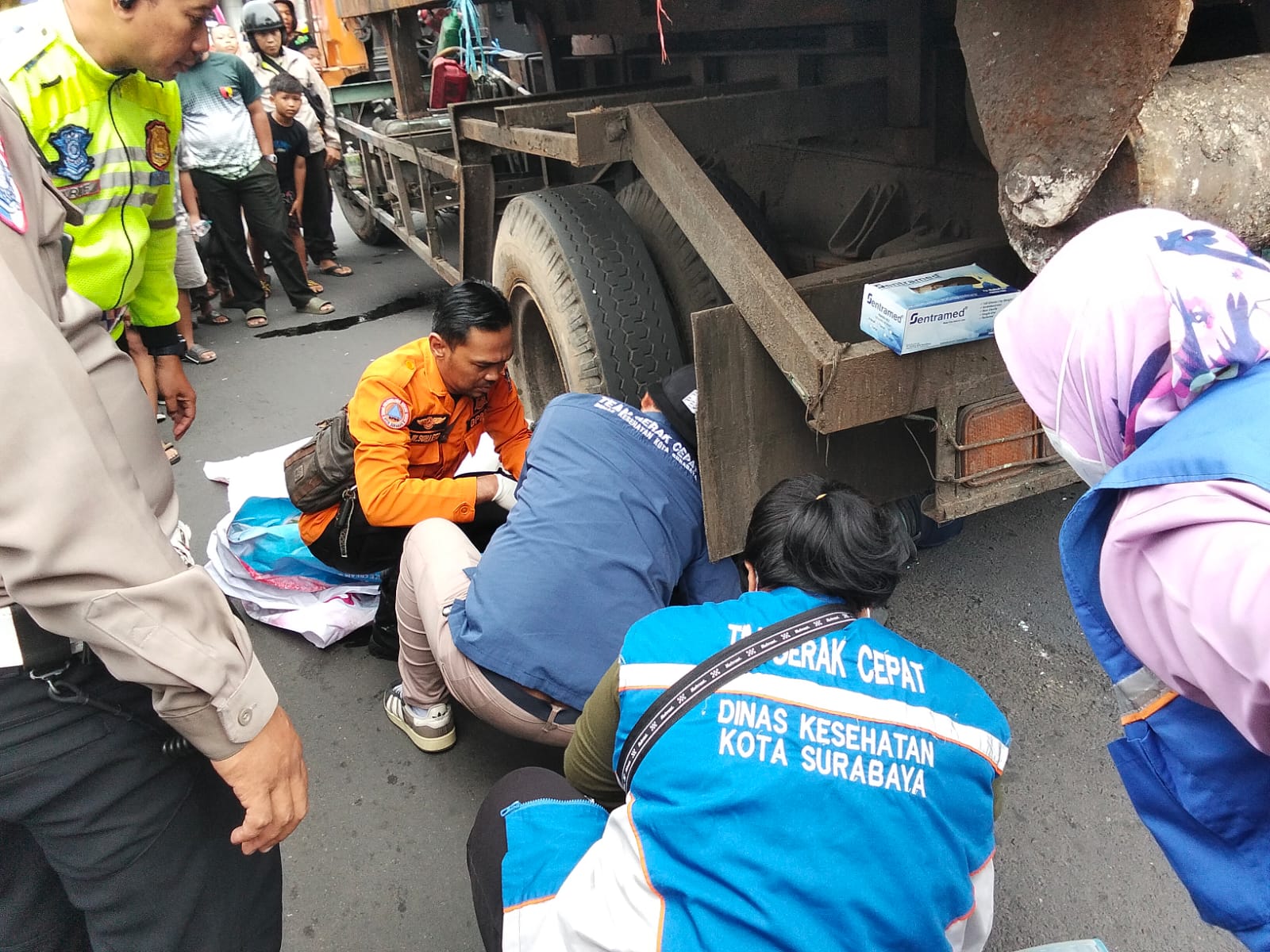 EVAKUASI : Petugas saat mengevakuasi korban pengendara motor yang terlindas truk sampah di Jalan Bubutan, Surabaya. (IST/RADAR SURABAYA)