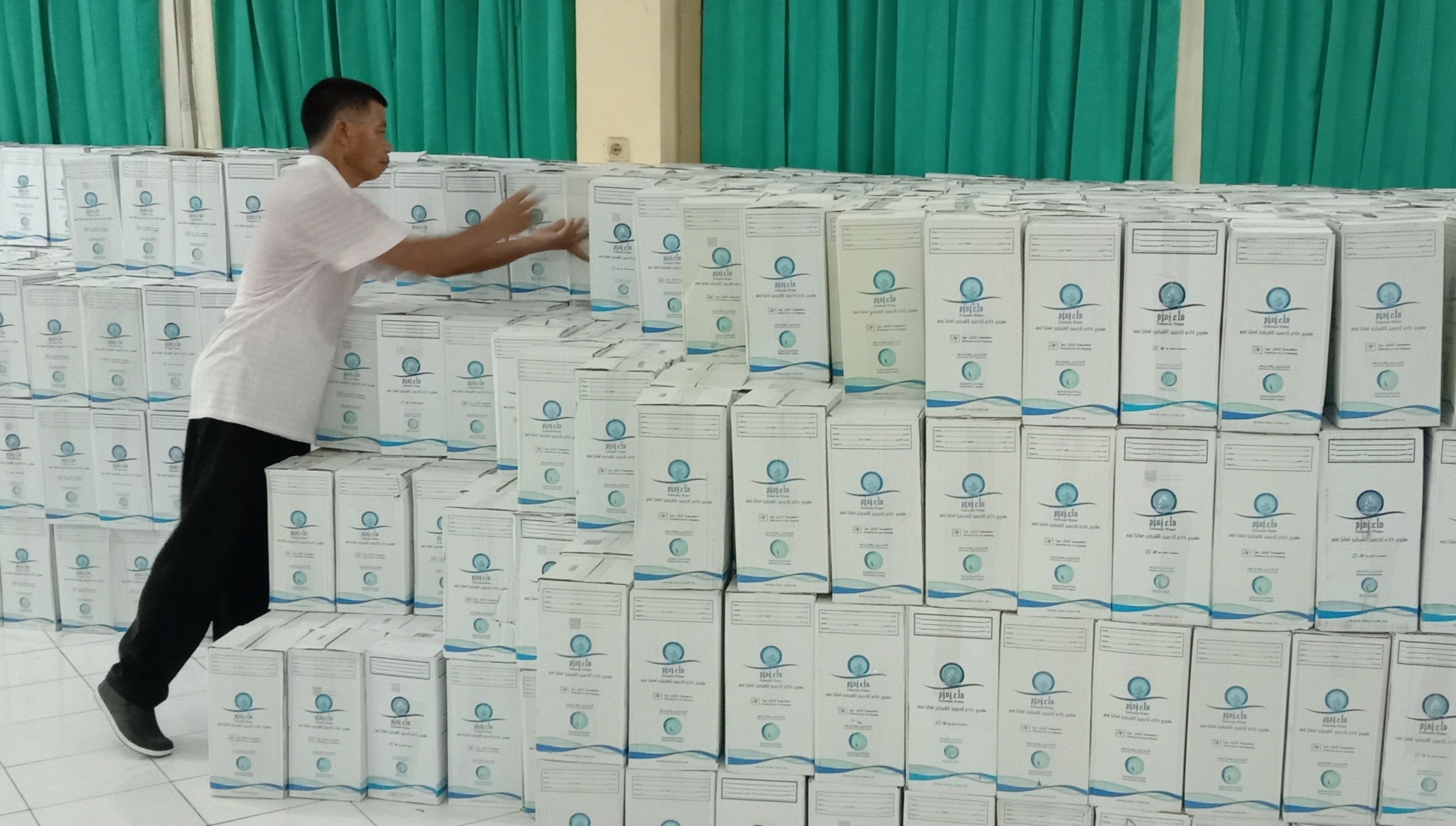 TIBA: Sebanyak 3.000 kardus yang berisi air zamzam 5 liter saat diturunkan dari truk di Asrama Haji Embarkasi Surabaya, Senin (19/5).