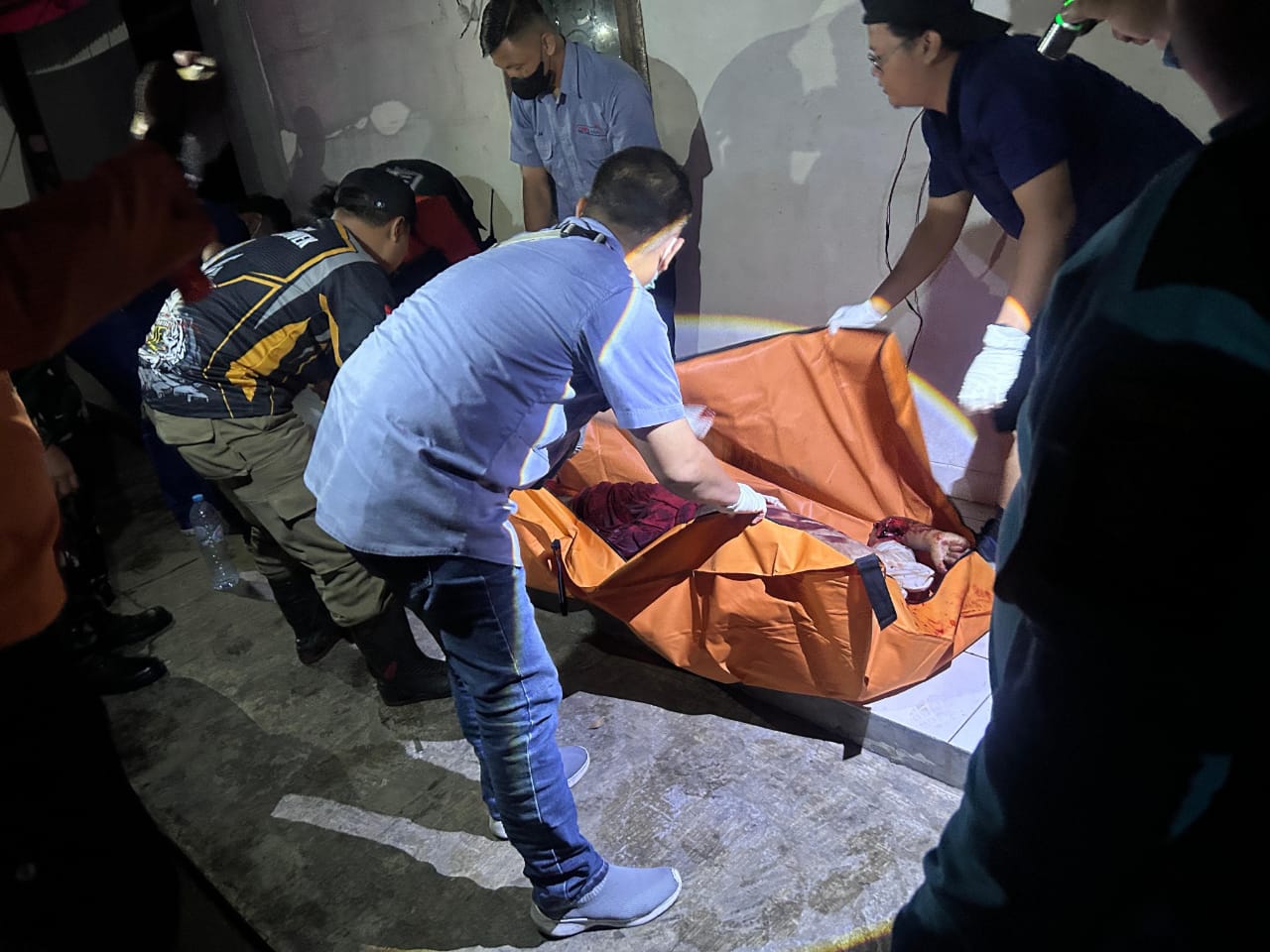 EVAKUASI : Korban saat dievakuasi petugas di Kedinding Lor, Surabaya. Korban diduga meninggal dunia karena dibacok. (IST/RADAR SURABAYA)