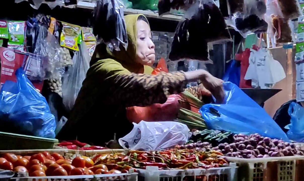 MELAMBUNG: Salah satu pedagang di Pasar Dukuh Kupang Surabaya tengah melayani pembeli.