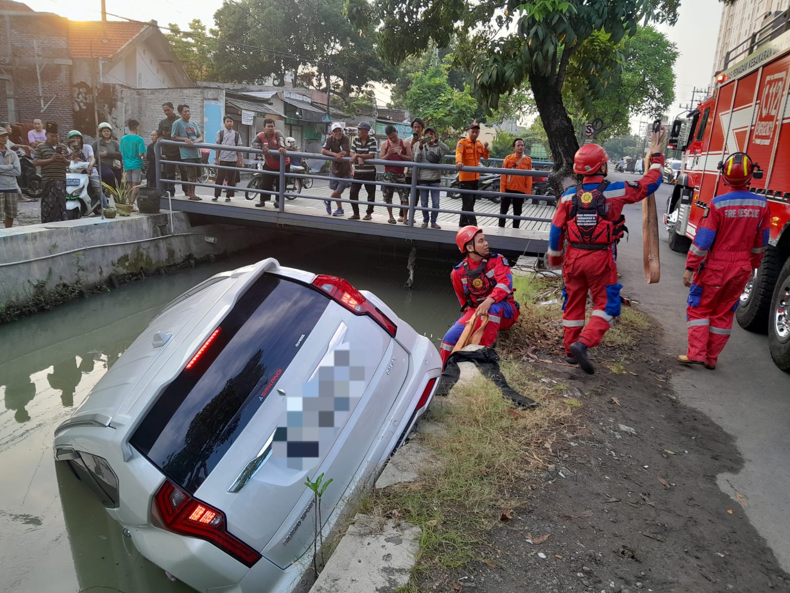 DIANGKAT : Petugas DPKP Surabaya saat mengevakuasi mobil Mitsubishi Pajero yang tercebur ke sungai di Menur Pumpungan, Surabaya. (IST/RADAR SURABAYA)