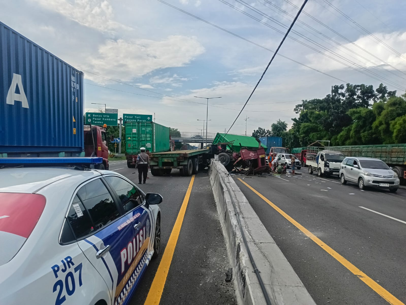 HANCUR : Kondisi truk kontainer usai menabrak pembatas beton dan tiang PJU di Tol Surabaya. (IST/RADAR SURABAYA)