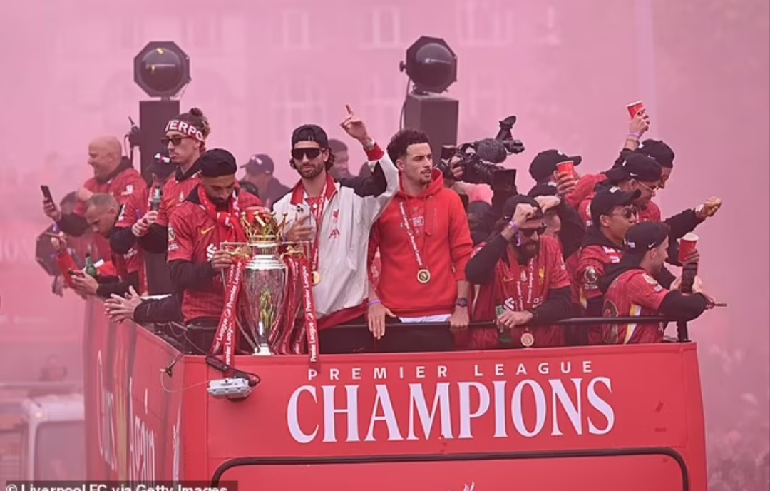Asap merah menyelimuti parade juara dengan beberapa pemain tim utama Liverpool terlihat di tingkat atas bus.