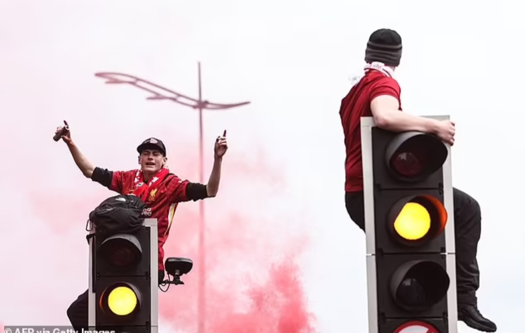 Beberapa suporter memanjat lampu lalu lintas saat sejumlah jalan di kota ditutup pada hari Senin