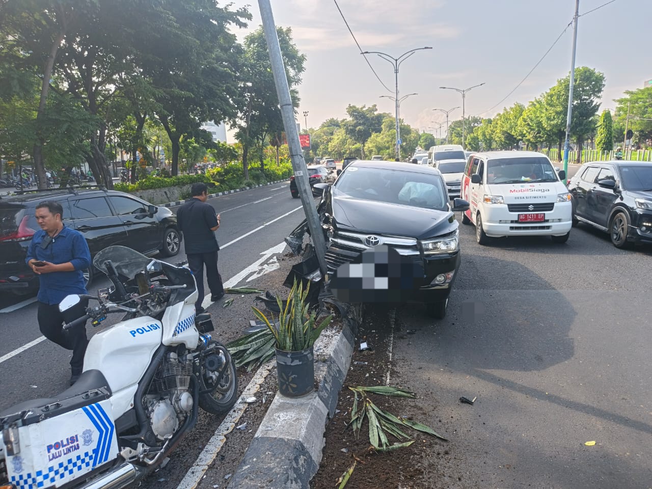 RINGSEK : Kondisi mobil Toyota Innova Reborn yang dikemudikan EP menabrak tiang PJU di Jalan Ahmad Yani, Surabaya Kamis (29/5). (IST/RADAR SURABAYA)