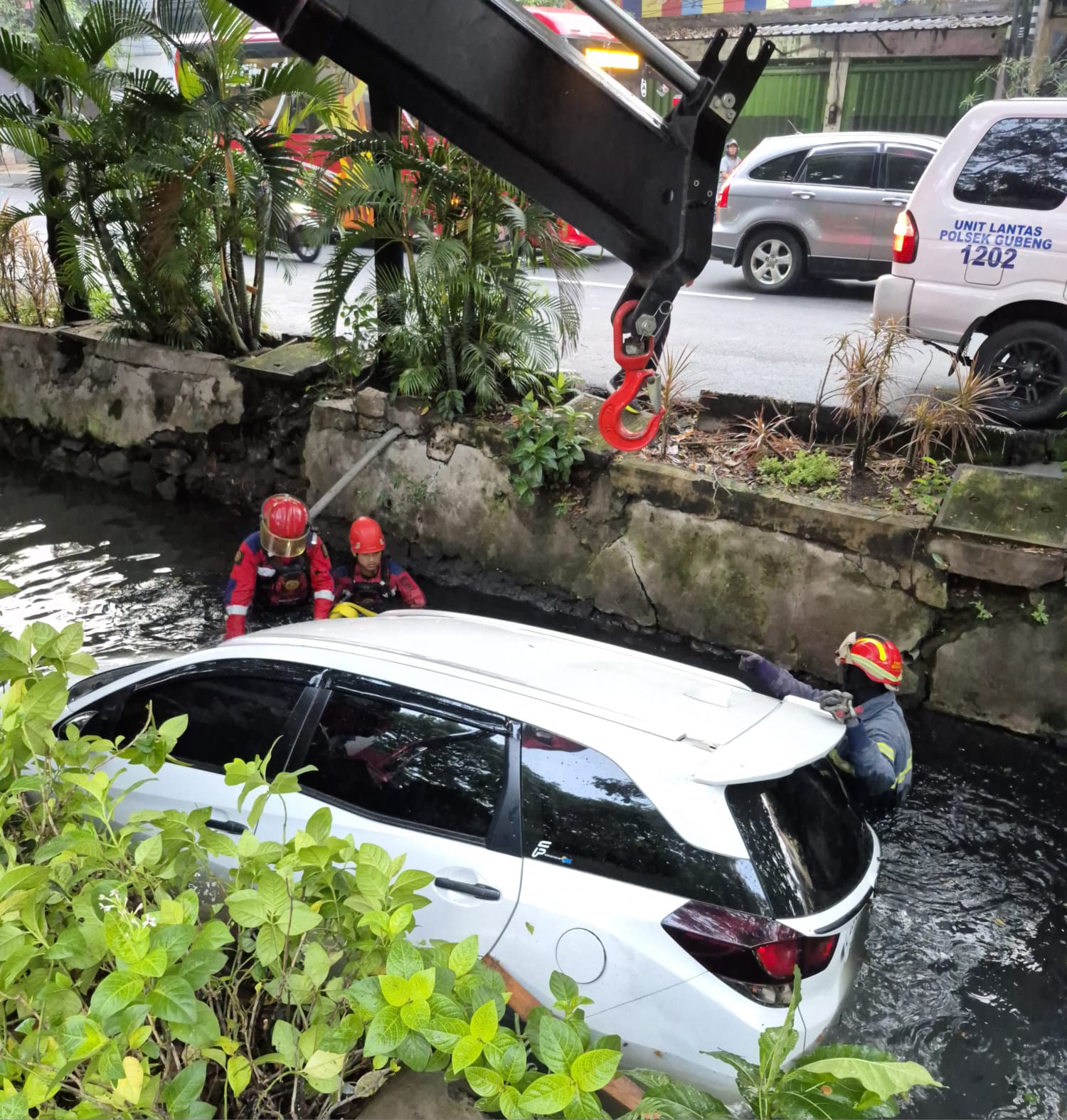 DIEVAKUASI : Mobil Mobilio yang tercebur di sungai Jalan Nginden Kota, Surabaya, Minggu (1/6) pagi. (IST/RADAR SURABAYA)
