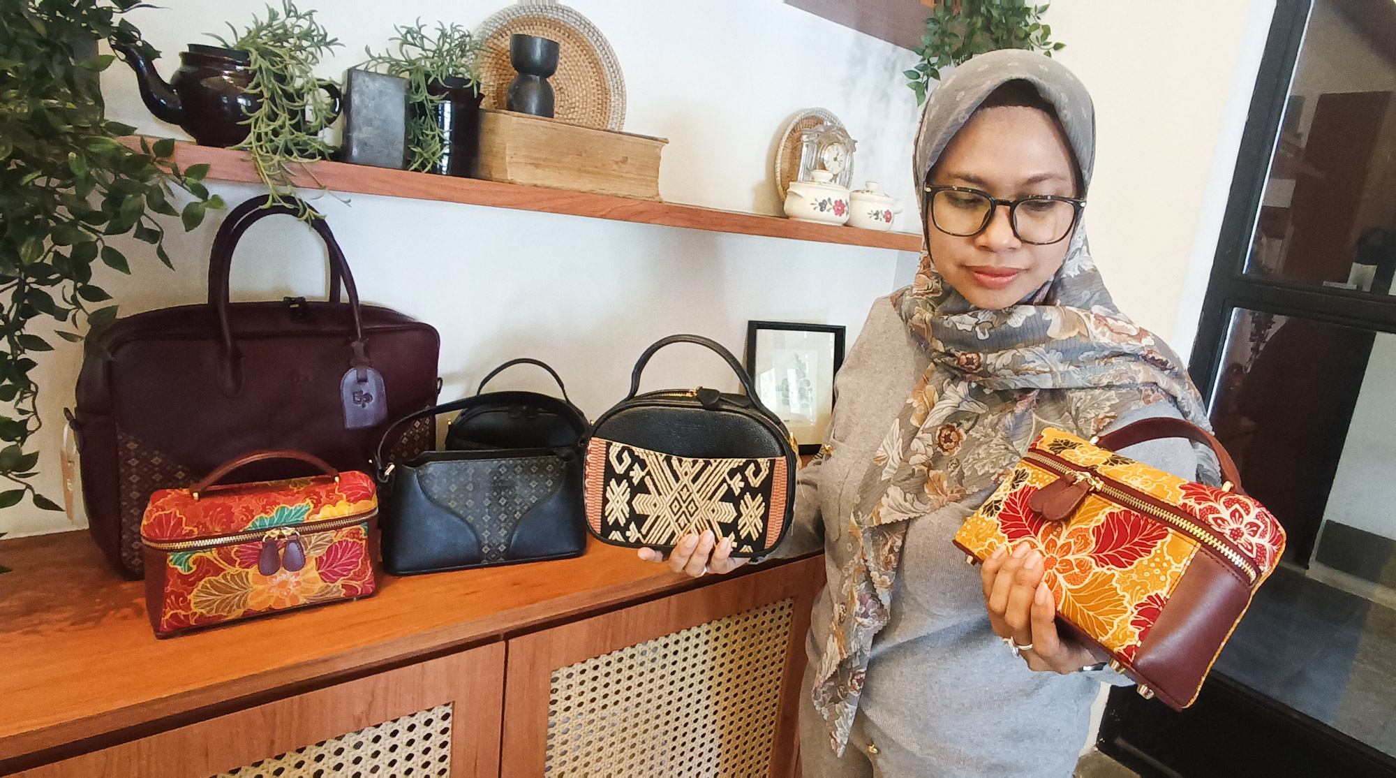 KARYA PERAJIN LOKAL: Penggemar tas etnik ketika menunjukkan pouch bag berbahan kulit yang dipadukan dengan kain batik koleksi Etnapraya, di Surabaya, Selasa (3/6).&nbsp;