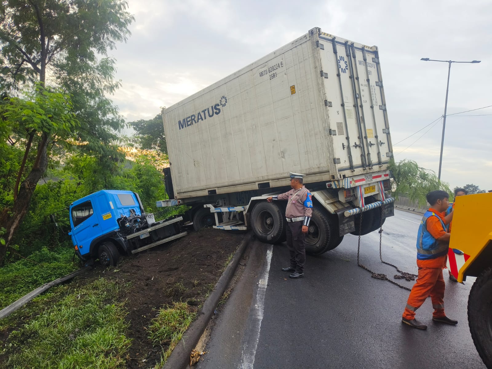 DITARIK : Truk kontainer yang terperosok di parit KM 12.200 Tol Satelit, Surabaya, arah Waru berhasil dievakuasi dan lalu lintas kembali normal. (IST/RADAR SURABAYA)