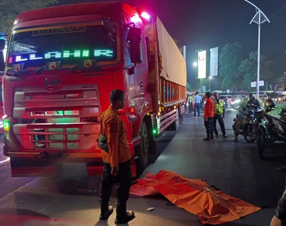 Polisi mengamankan lokasi kecelakaan yang menewaskan seorang tukang becak yang tertabrak truk.