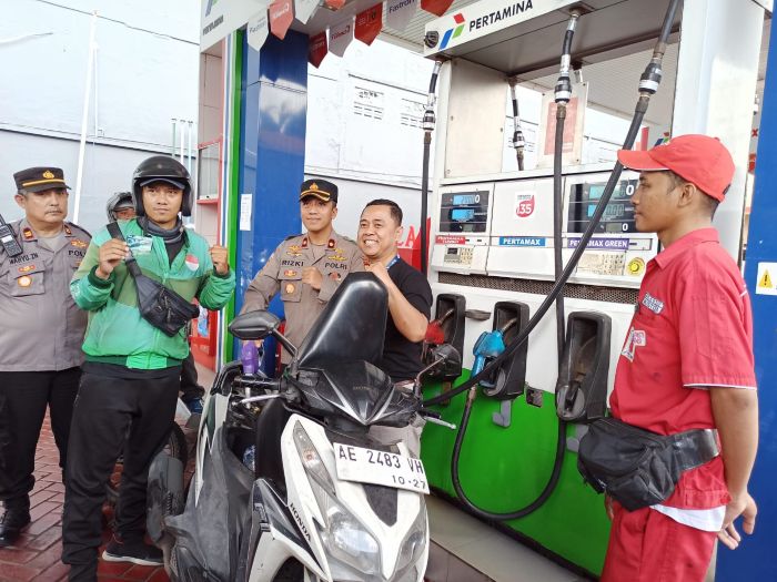 EMISI KARBON: Wawan Heri Purnomo (dua dari kanan) dan Kompol Rizki Santoso (tiga dari kanan) menyaksikan salah satu driver ojol isi BBM ramah lingkungan, Pertamax Green 95 di SPBU Tegalsari Surabaya