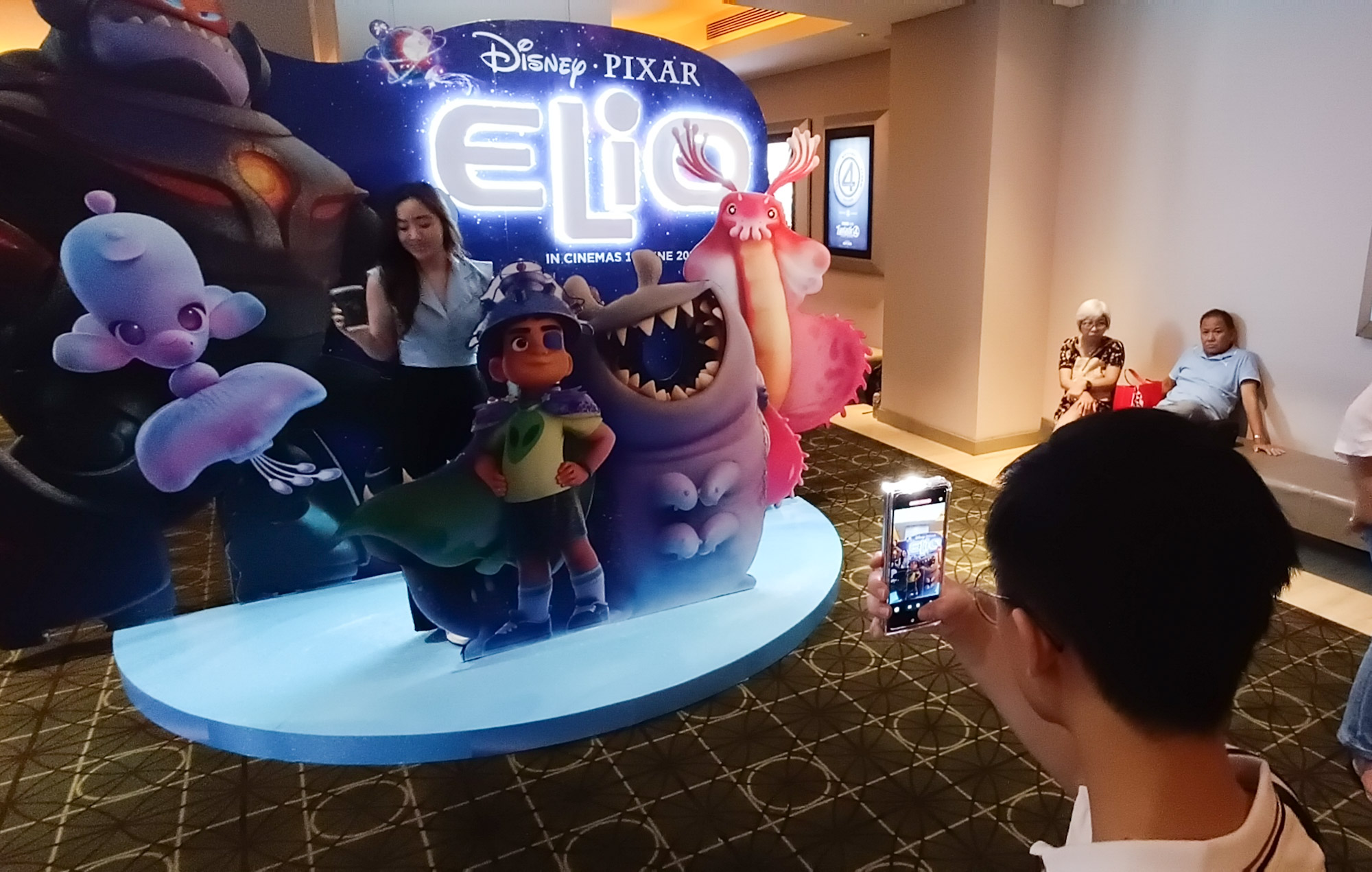 ANTUSIAS: Sejumlah penonton berfoto dengan latar belakang instalasi film Elio yang dipasang di depan pintu masuk studio bioskop, di XXI Tunjungan Plaza 5 Surabaya.