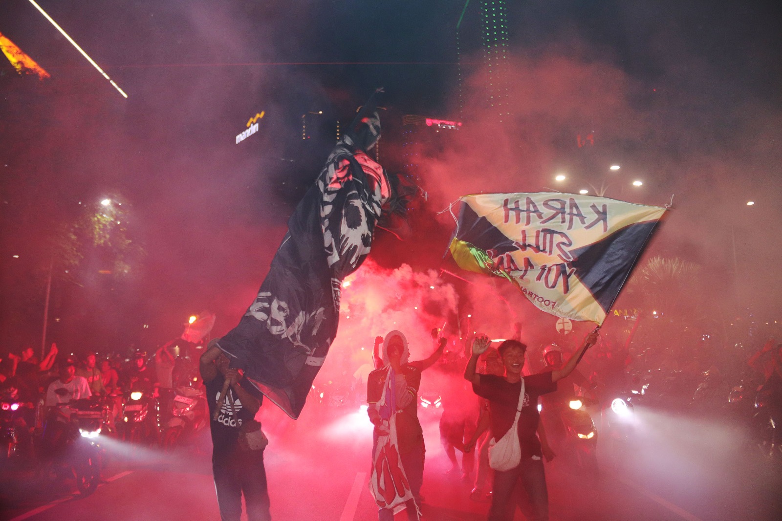 BERKIBAR : Bendera klub kebanggaan terus dikabarkan suporter. Semakin malam jumlah mereka semakin banyak dan memenuhi jalanan tengah kota Surabaya. (ANDY SATRIA/RADAR SURABAYA)