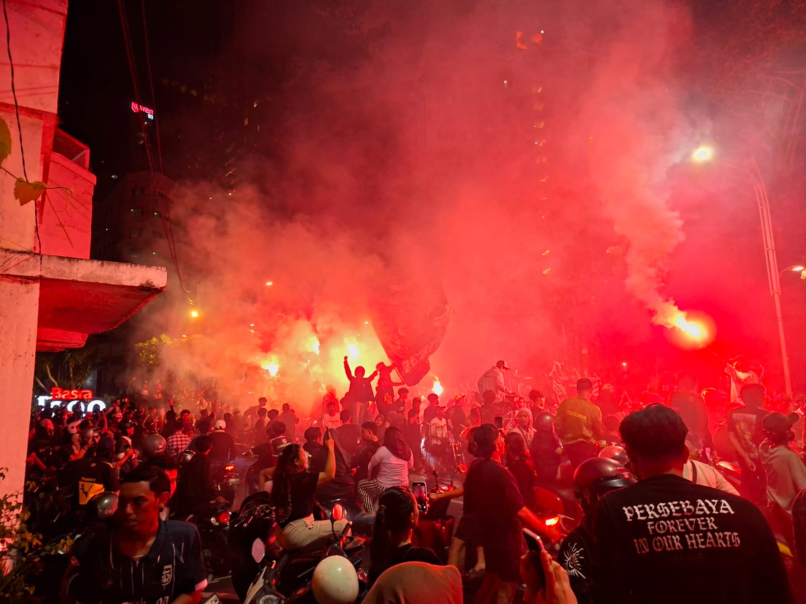 Ribuan Bonek memadati Jalan Gubernur Suryo Surabaya sambil menyalakan flare.