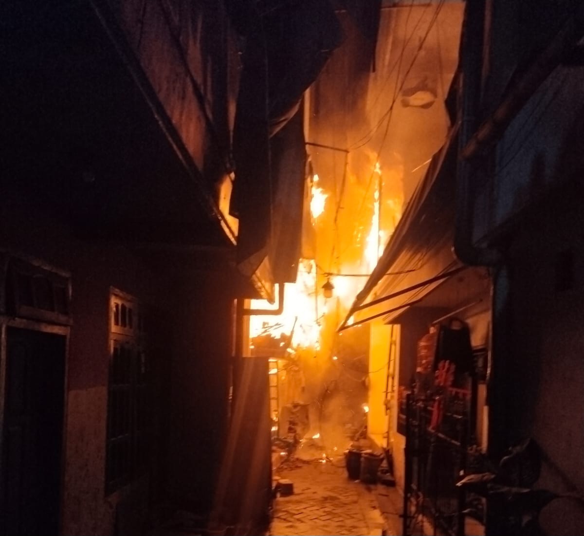 MENYALA : Api yang membakar bangunan rumah semi permanen di kawasan Kalimas Baru, Surabaya. (IST/RADAR SURABAYA)