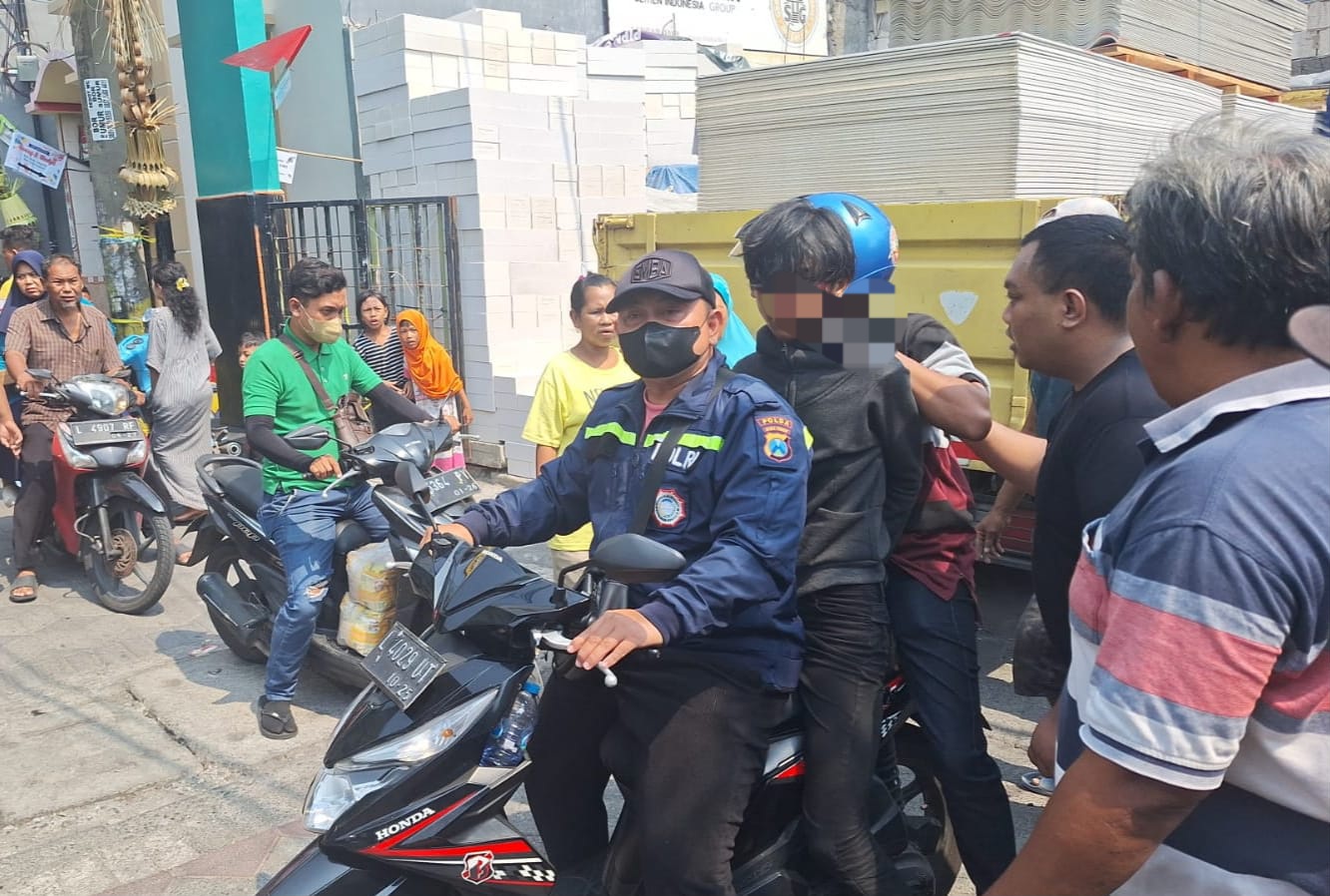 PASRAH : Pelaku pencuri motor AGP, 20, tak berkutik setelah dihajar massa di Jalan Kapas Madya, Surabaya.(IST/RADAR SURABAYA)