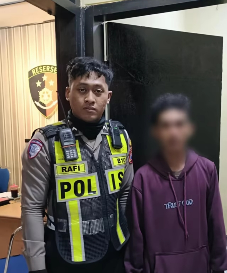 BERHASIL : Anggota Satlantas Polrestabes Surabaya Bripda Rafi saat membawa pelaku curanmor ke Polsek Gubeng usai dihajar massa di Jalan Dharmawangsa, Surabaya. (IST/RADAR SURABAYA)