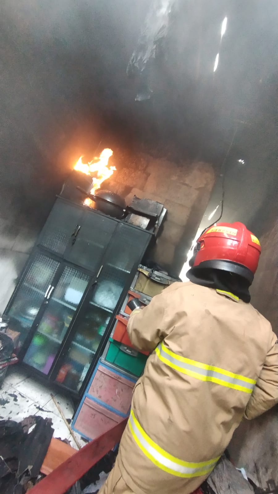 PEMADAMAN : Petugas DPKP Surabaya memadamkan api yang membakar rumah di Jalan Bendul Merisi Jaya, Surabaya. (IST/RADAR SURABAYA)