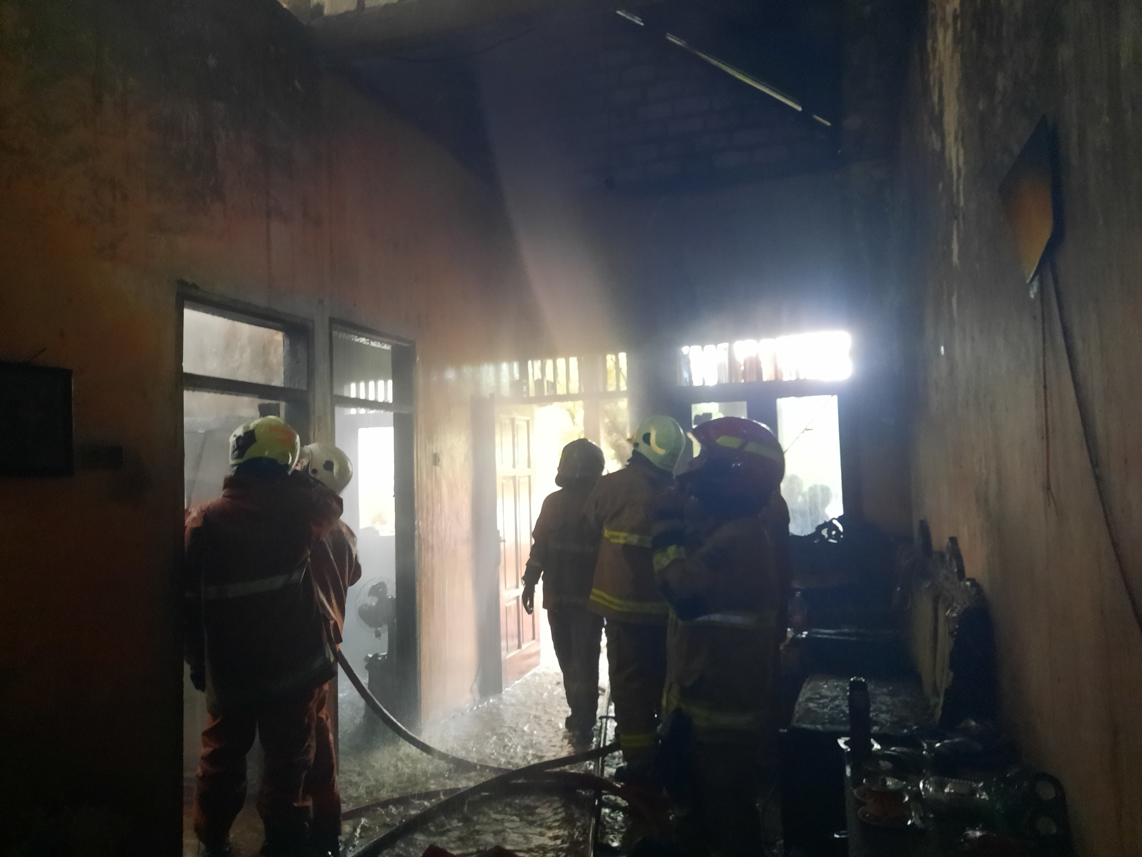 SIGAP : Petugas DPKP Surabaya melakukan pembasahan di rumah Surip warga Jalan Sumberejo Makmur IV, Pakal Surabaya, Minggu (29/6). (IST/RADAR SURABAYA)