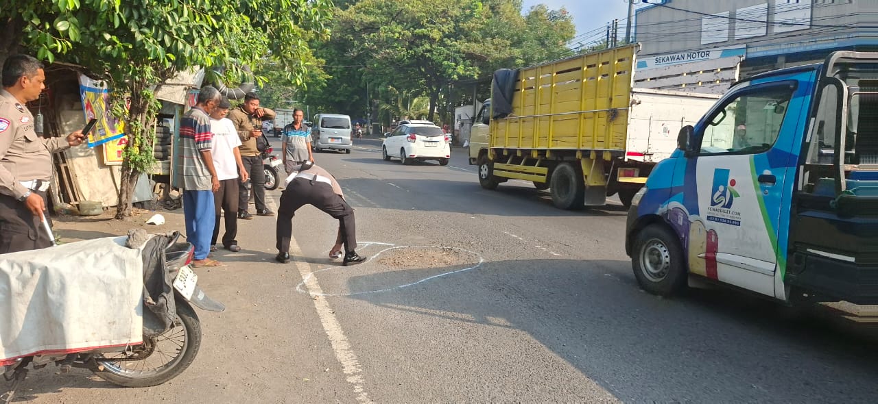 LOKASI : Polisi melakukan olah TKP di lokasi kecelakaan motor dan truk trailer di Jalan Mastrip, Karangpilang, Surabaya, Kamis (3/7). (M MAHRUS/RADAR SURABAYA)