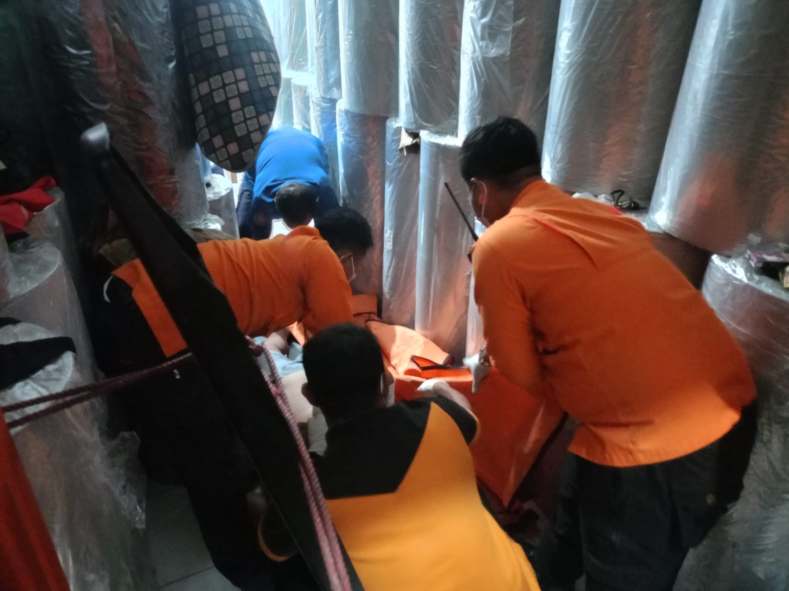 EVAKUASI : Petugas saat mengevakuasi jenazah sopir yang ditemukan meninggal di salah satu ruko kawasan Jalan Raya Pandugo, Surabaya. (IST/RADAR SURABAYA)