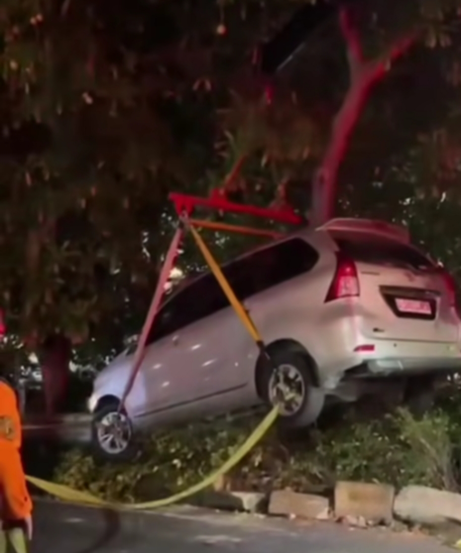 LAKA TUNGGAL : Petugas gabungan mengevakuasi mobil yang menabrak pembatas jalan di Jalan Semolowaru Surabaya, Sabtu (12/7). (IST/RADAR SURABAYA)