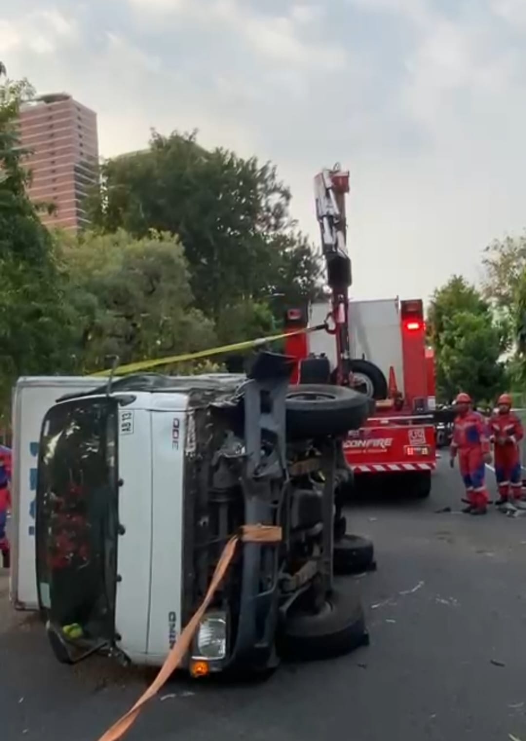 DITUTUP : Petugas DPKP Surabaya mengevakuasi truk boks yang terguling di Jalan Ahmad Yani, Surabaya. (IST/RADAR SURABAYA)