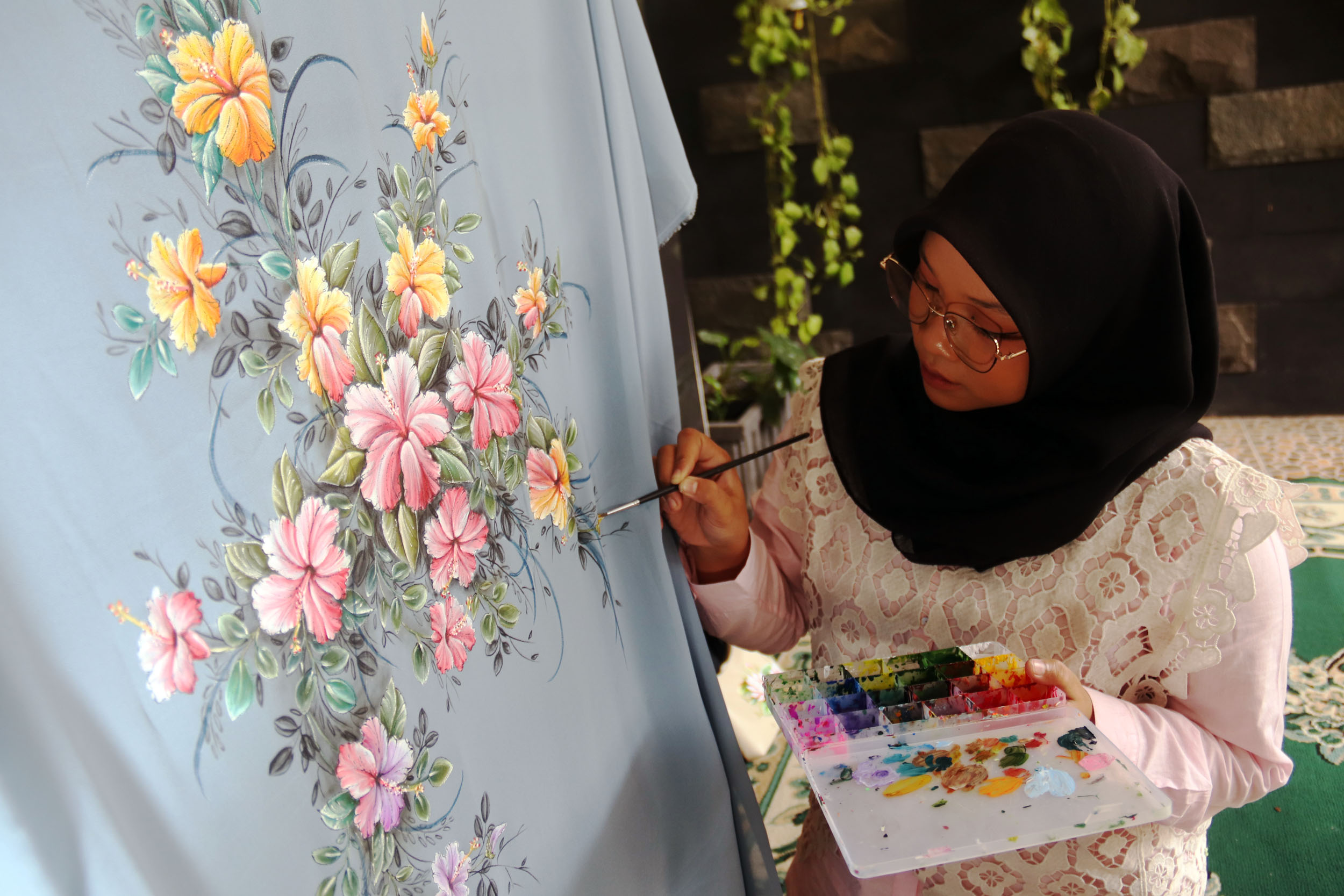 HAND PAINTING: Faula Madyana, melukis pakaian pesanan pelanggan Zenea Lukis, di tokonya kawasan Jambangan Surabaya, Selasa (14/7).