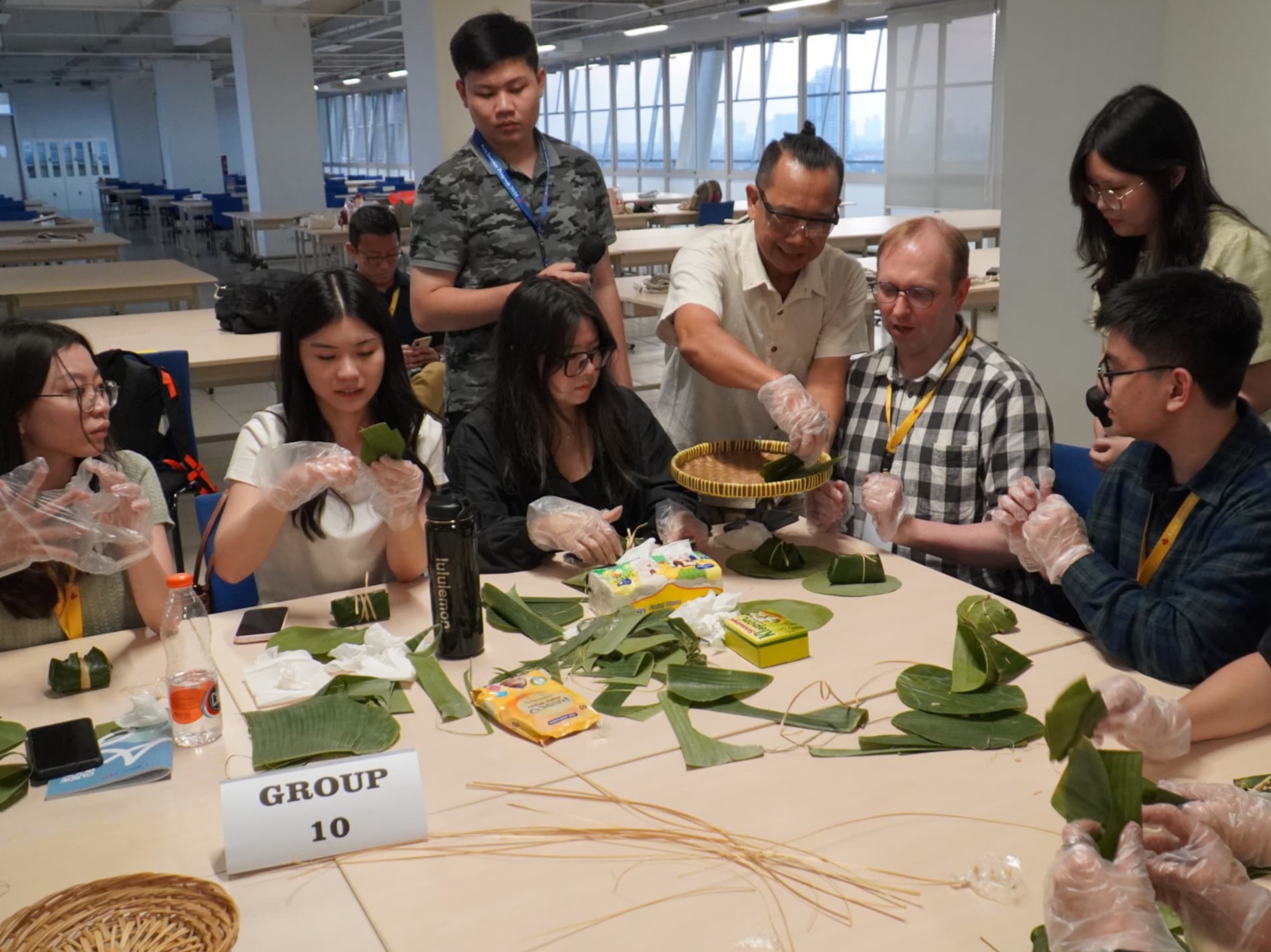 BUAT LEMPER: Mahasiswa dari berbagai negara saat belajar membungkus lemper di PCU Surabaya dalam libur musim panas.