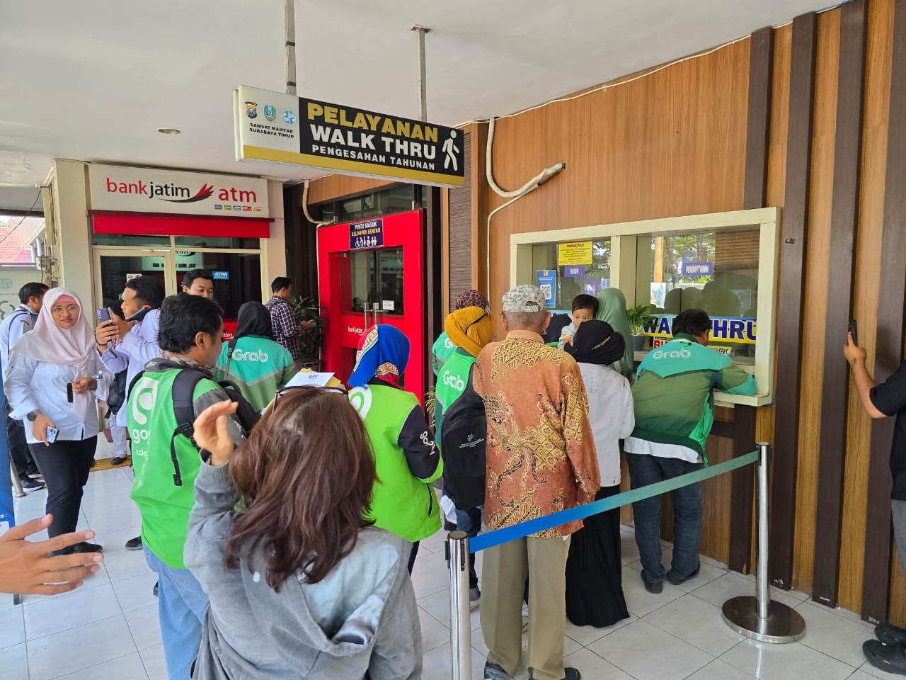 Drive ojek online saat mengantre membayar pajak kendaraan bermotor.