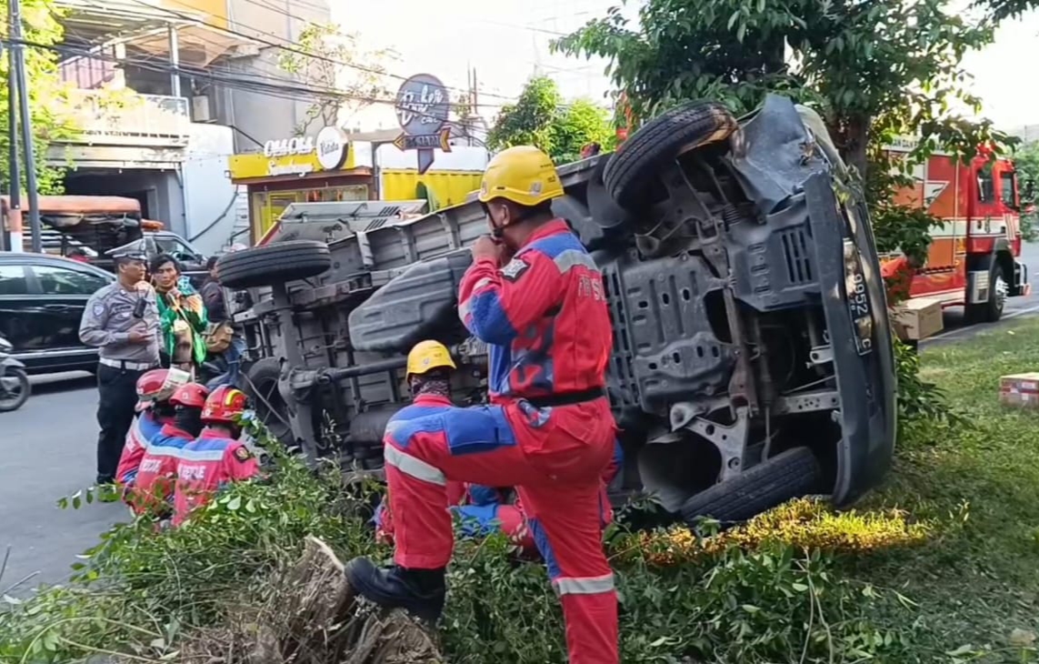 EVAKUASI : Tim Rescue DPKP Surabaya saat mengevakuasi mobil boks yang terguling di Jalan Jemursari, Surabaya.(IST/RADAR SURABAYA)