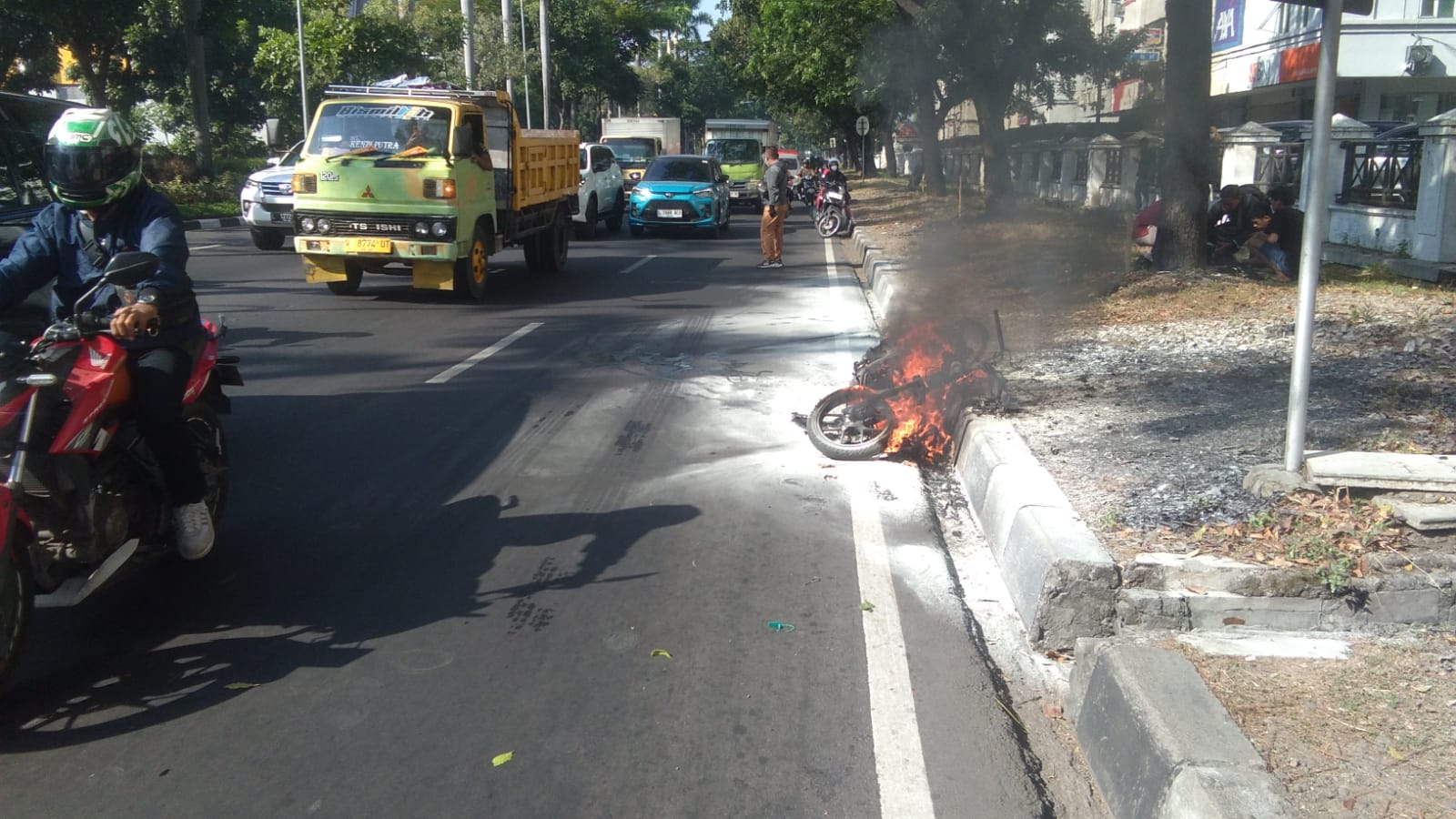 PANAS : Kondisi motor saat terbakar di pinggir Jalan Raya Ir Soekarno, Merr, Sukolilo, Surabaya.(LAMBERTUS HUREK/RADAR SURABAYA)