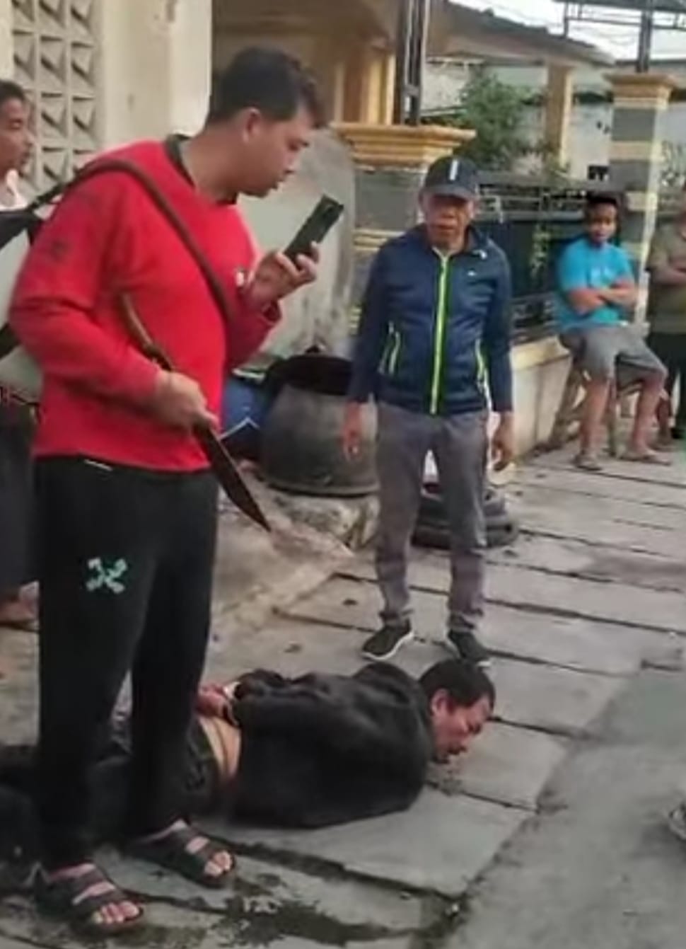 TERTANGKAP : Pencuri motor saat diamankan massa. Ia sempat dihajar massa di Jalan Wonorejo, Manukan, Surabaya. (IST/RADAR SURABAYA)