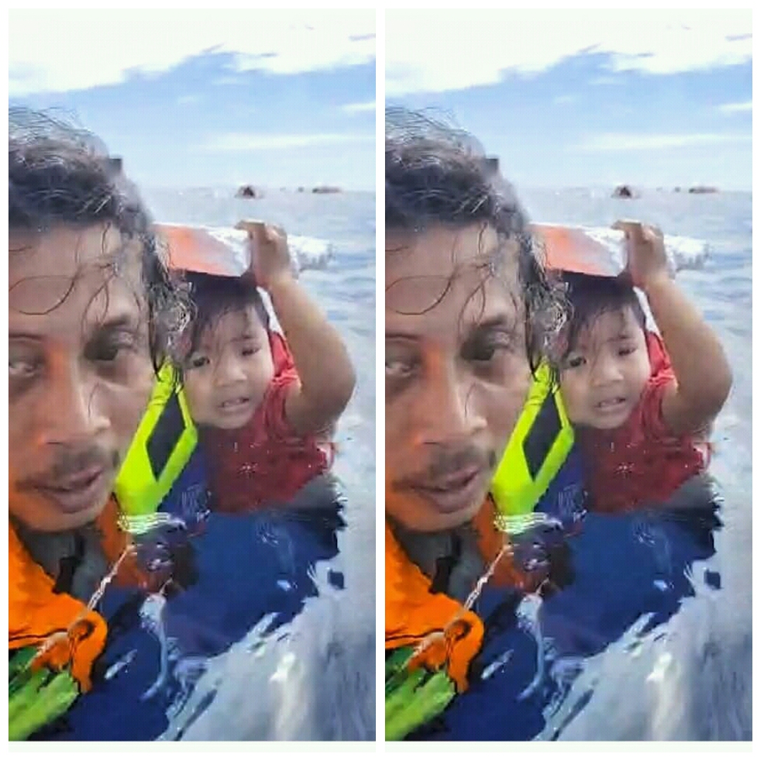 Abdul Rahman menggendong balita dalam tragedi Kapal Barcelona 5 terbakar di perairan Minahasa. (IST)