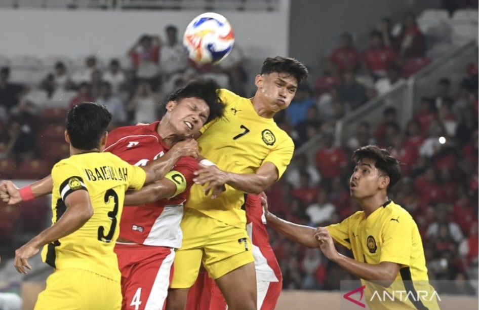 Kadek Arel Priyatna Berebut bola si udara dengan pemain Malaysia.