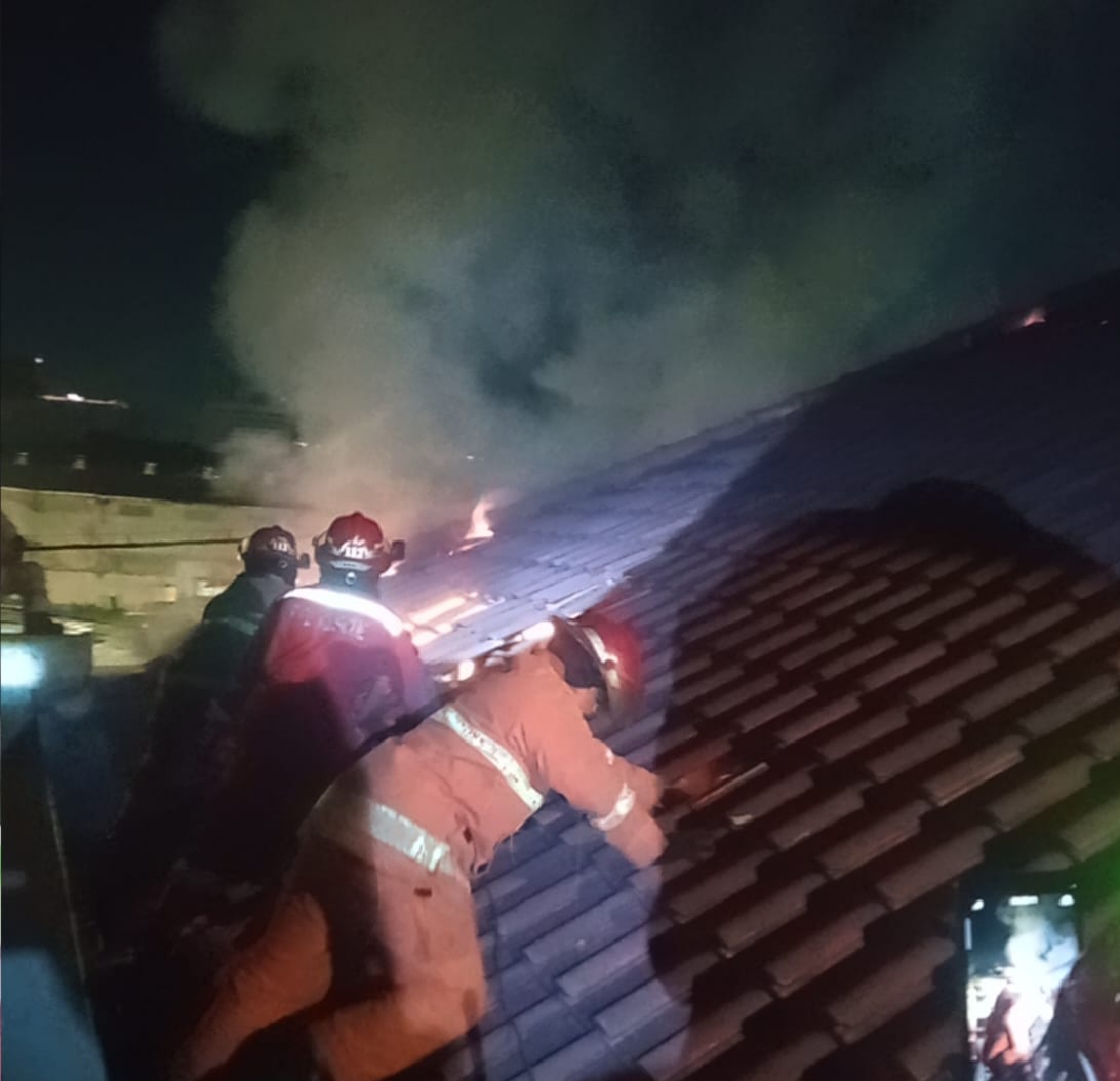KERJA KERAS : Petugas DPKP Surabaya saat memadamkan api yang membakar atap dan plafon rumah Budi S di Jalan Jimerto, Surabaya, Rabu (23/7). (IST/RADAR SURABAYA)