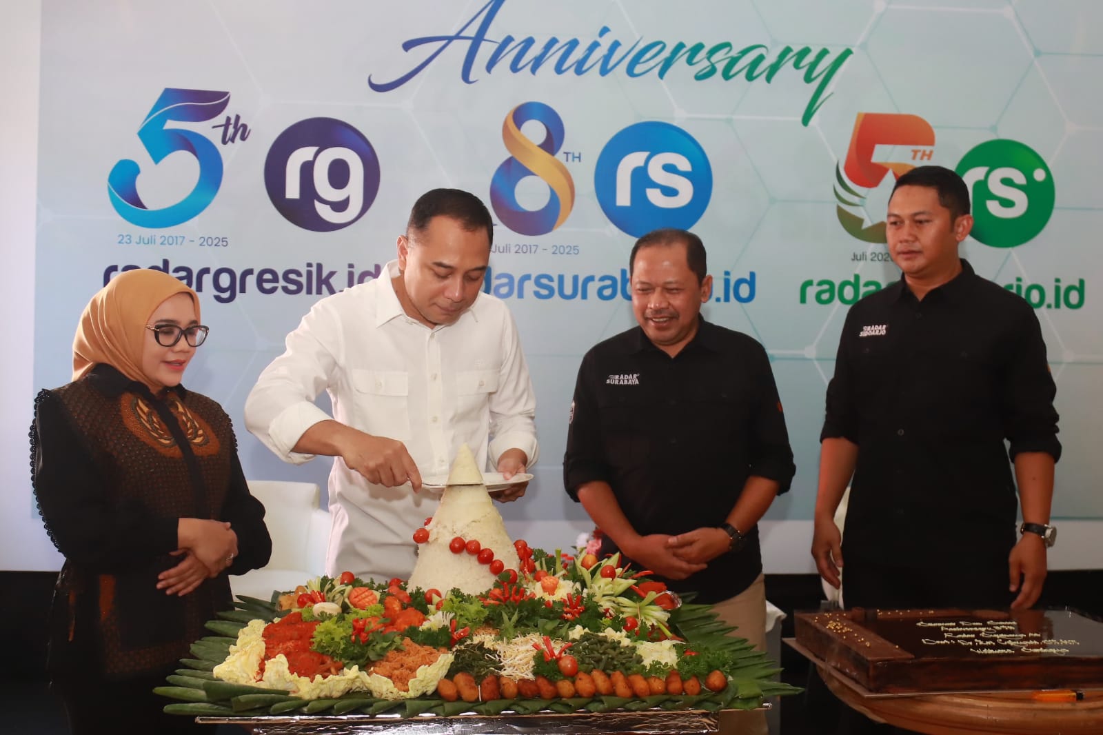 Wali Kota Surabaya Eri Cahyadi didampingi Ketua TP PKK Kota Surabaya Rini Indriyani memotong tumpeng syukuran HUT media online Radar Surabaya didampingi Direktur Radar Surabaya Lilik Widyantoro.