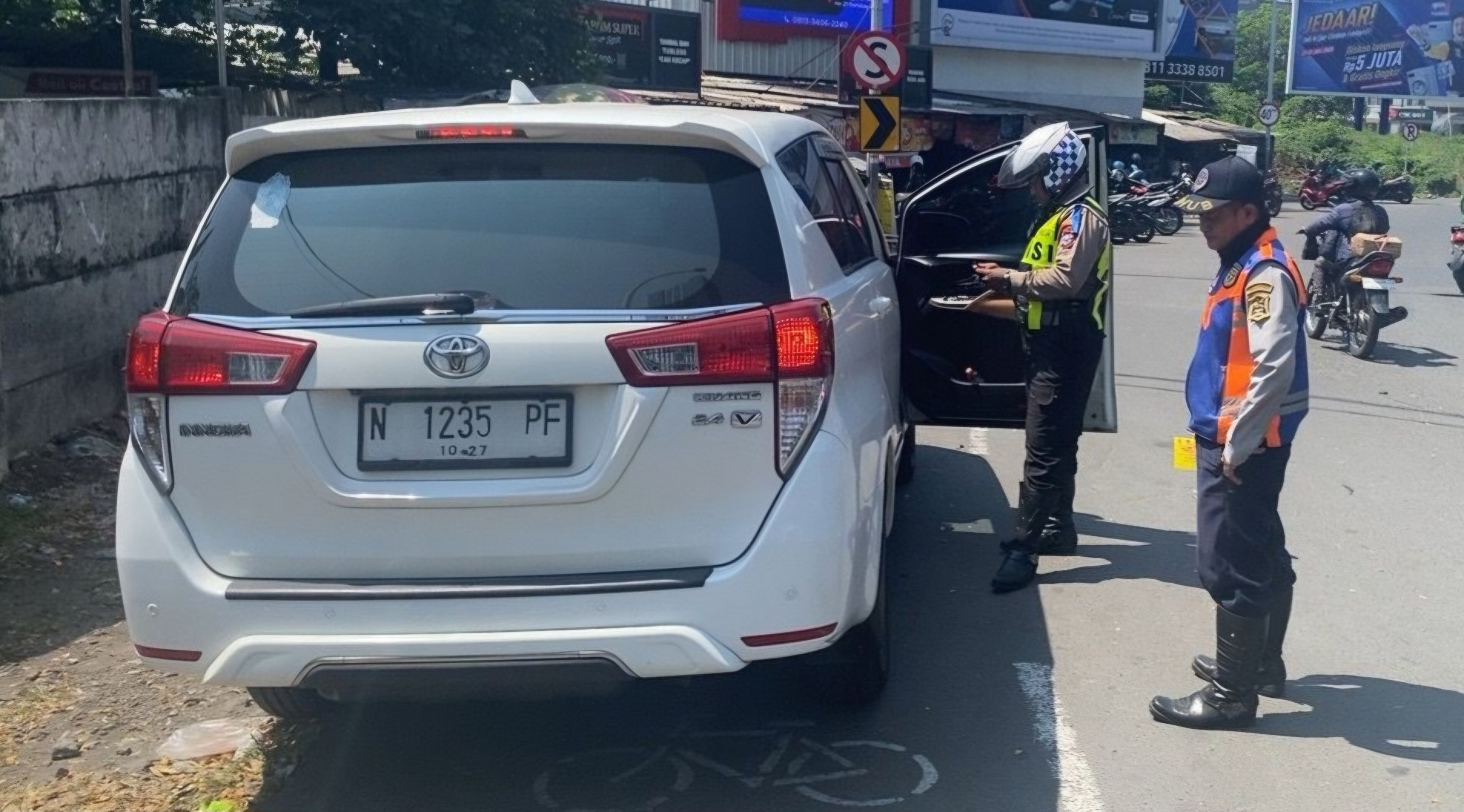 TEGURAN : Anggota Satlantas Polrestabes Surabaya menertibkan kendaraan yang parkir sembarangan dan di lokasi pedestrian. (IST/RADAR SURABAYA)