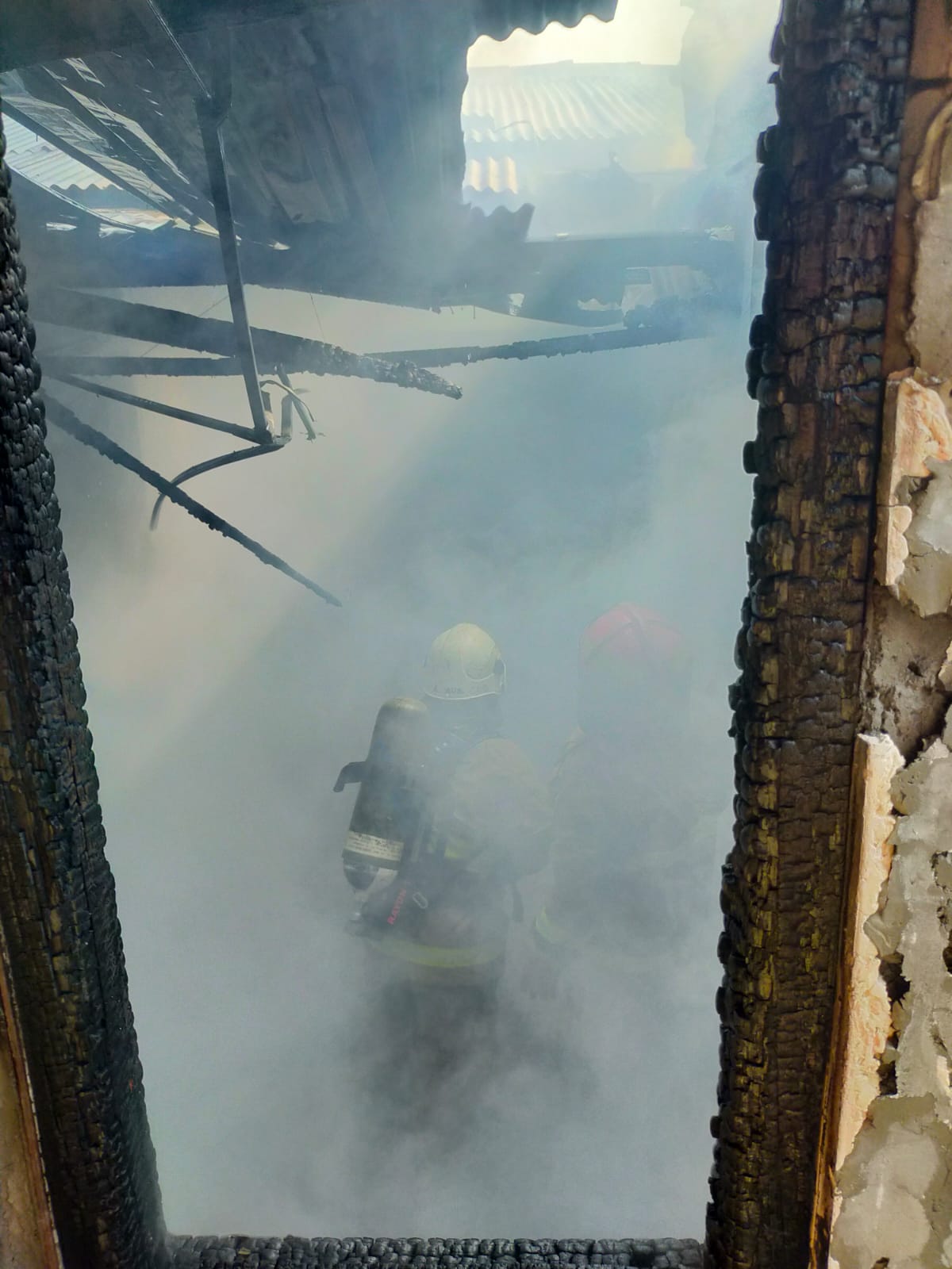 PEMADAMAN : Petugas DPKP Surabaya memadamkan api di rumah Jalan Wonosari Besar Blok K-2, Surabaya. Satu penghuni rumah mengalami luka bakar. (IST/RADAR SURABAYA)