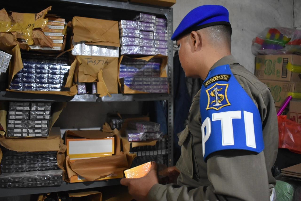 Petugas menyita rokok ilegal di salah satu toko di Surabaya. (IST)
