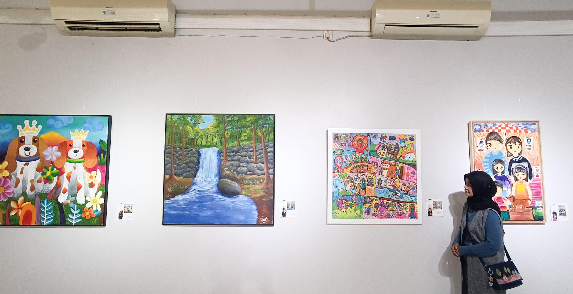 Pengunjung mengamati karya lukisan yang dipamerkan di Galeri Prabangkara, Komplek Taman Budaya Jatim, dari para perupa muda yang tergabung dalam komunitas Garis Gathuk dan Lotus Art Course.