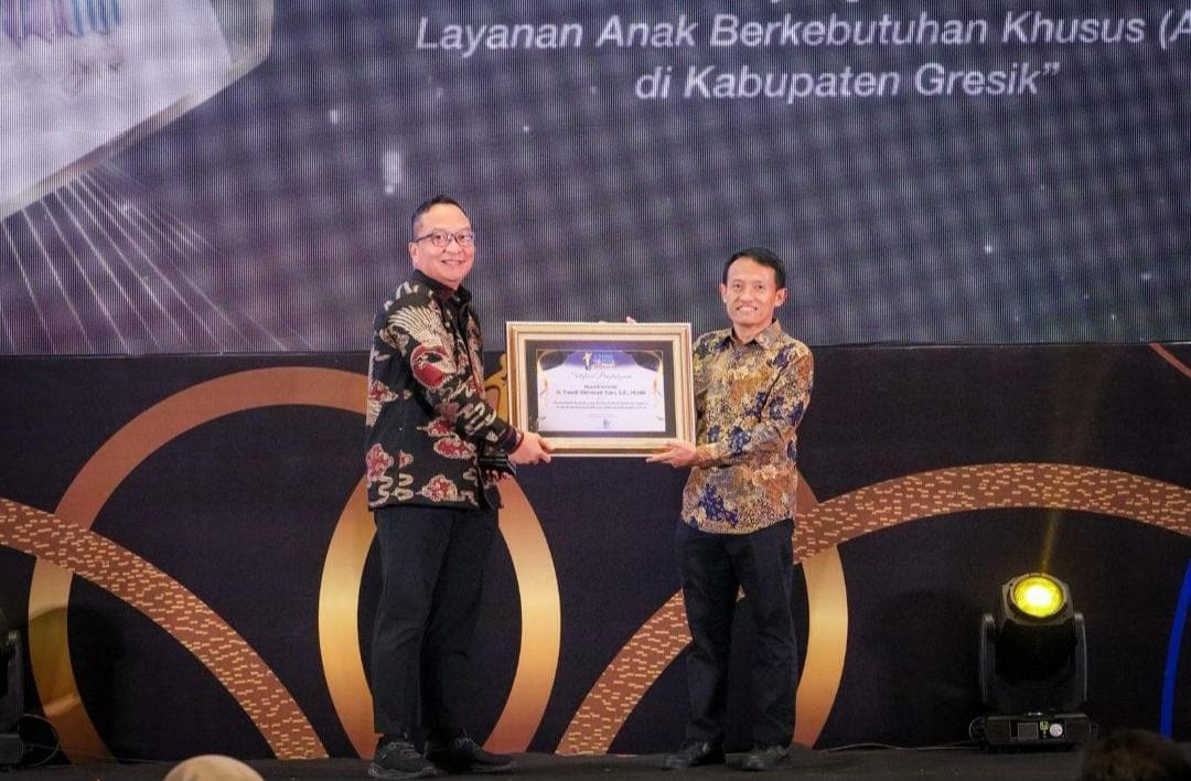 Direktur Utama Jawa Pos Group Leak Kustiya menyerahkan Radar Surabaya Award 2025 kepada Wakil Bupati Gresik dr. Asluchul Alif di Vasa Hotel Surabaya. (ANDY SATRIA/RADAR SURABAYA)