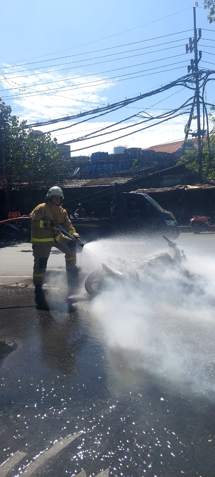PEMADAMAN : Petugas DPKP Surabaya saat memadamkan motor modifikasi yang terbakar di Jalan Margomulyo, Surabaya. (IST/RADAR SURABAYA)