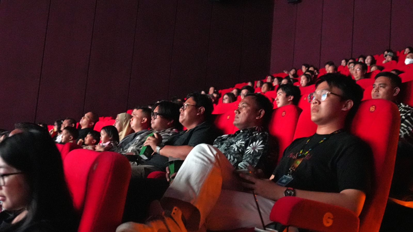 MENYIMAK: Suasana ruang teater saat penayangan perdana film NuShanTa(Ra). Penonton menikmati alur cerita kisah Rafael yang menyentuh dan sarat nilai kebersamaan. (IST/RADAR SURABAYA)