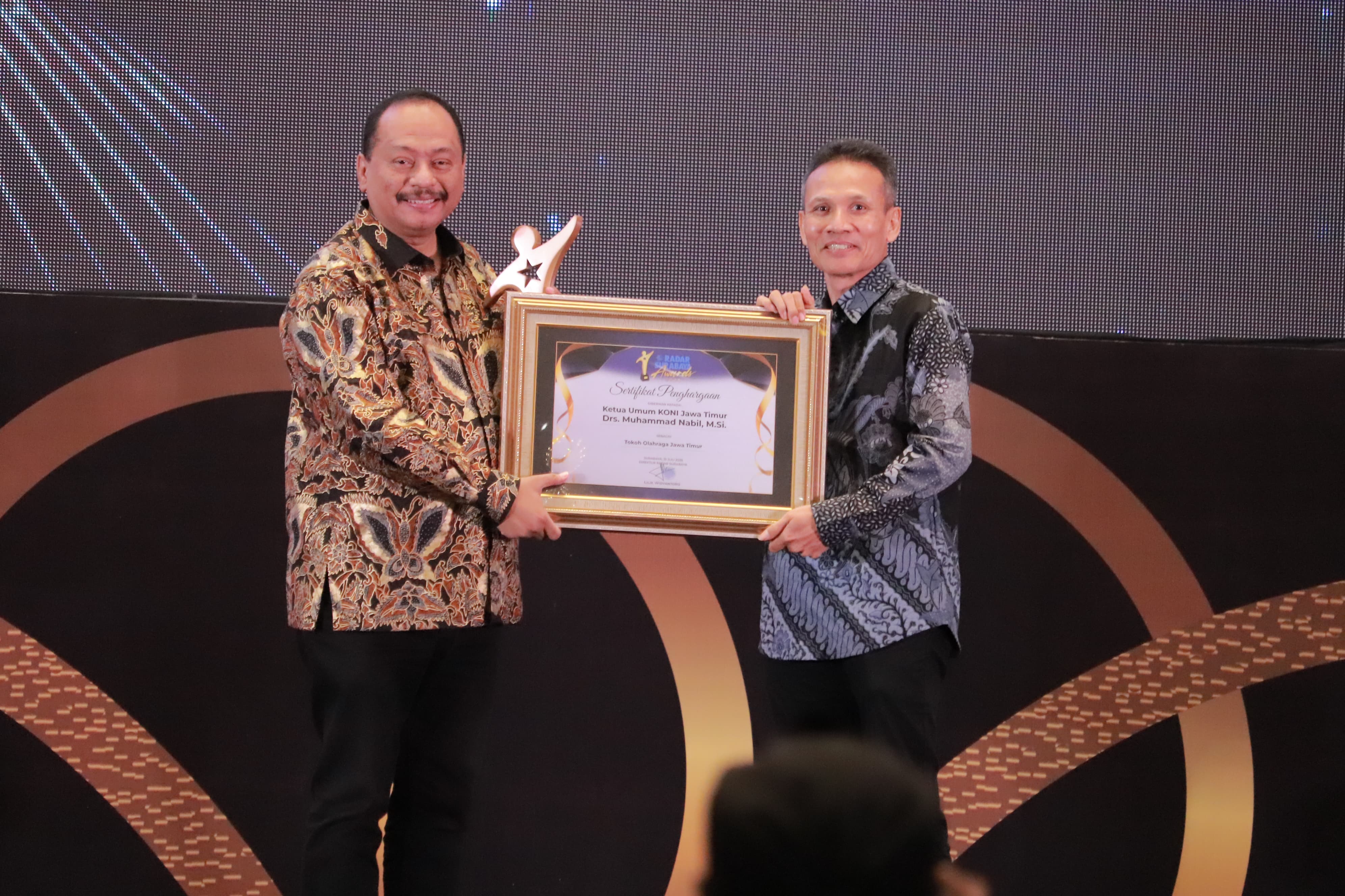 Muhammad Nabil (kiri) menerima trofi dan piagam penghargaan dari Direktur PT Jawa Pos Radar, Nur Wahid.