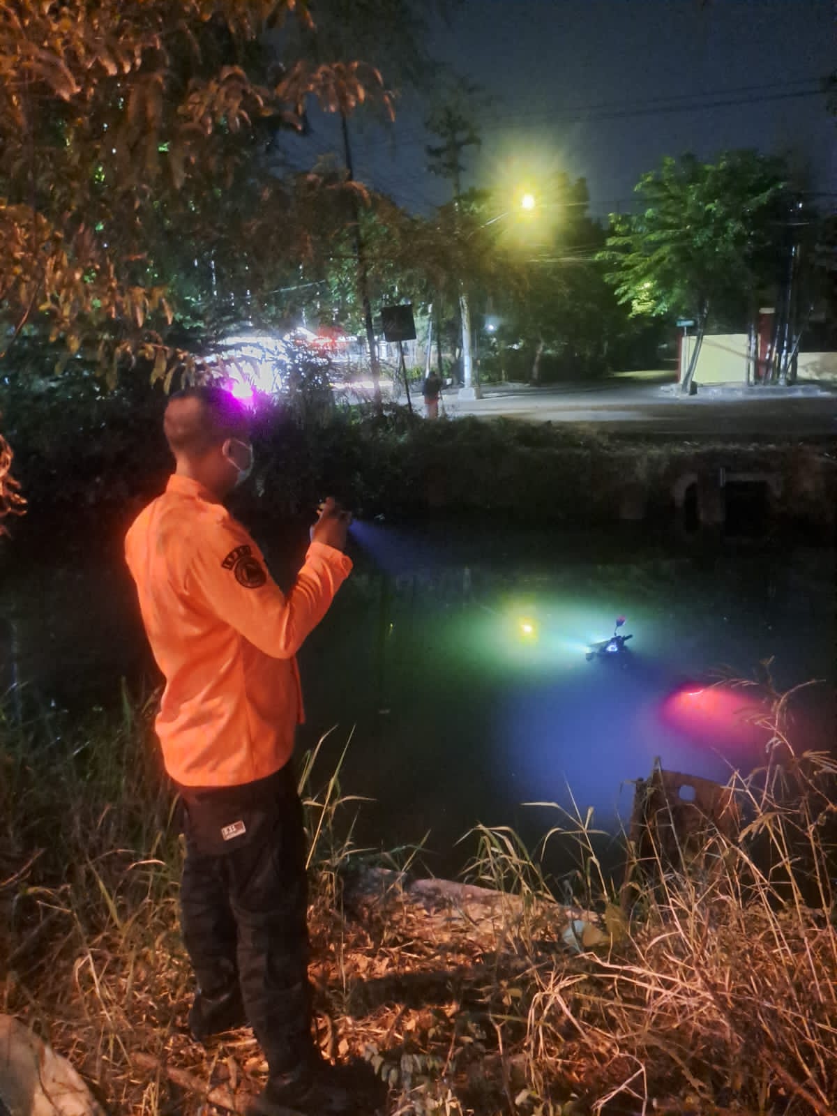 APES : Petugas BPBD Surabaya hendak mengevakuasi motor milik MF yang tercebur ke sungai di Jalan Arie Rahman Hakim, Sukolilo Surabaya.(IST/RADAR SURABAYA)