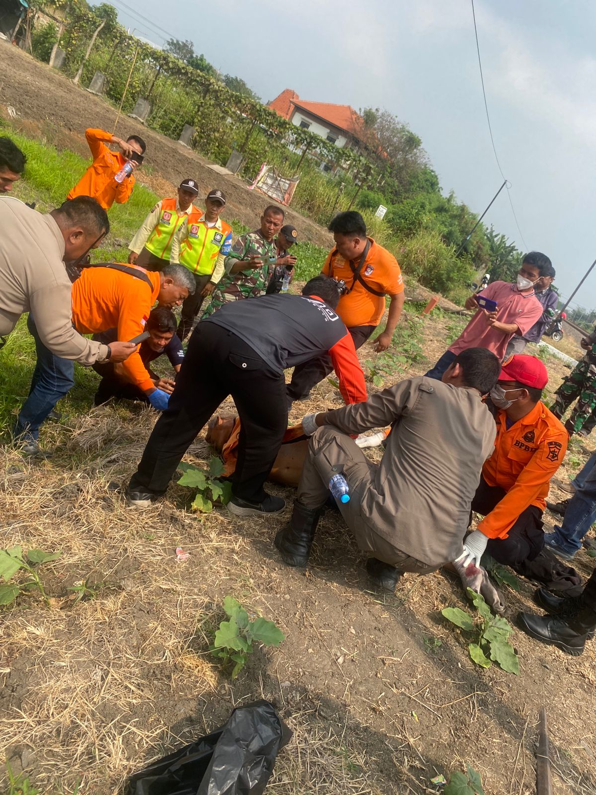 EVAKUASI : Petugas mengevakuasi jenazah korban Misno yang tertabrak KA Gumarang di perlintasan Babat Jerawat Pakal Surabaya. (IST/RADAR SURABAYA)