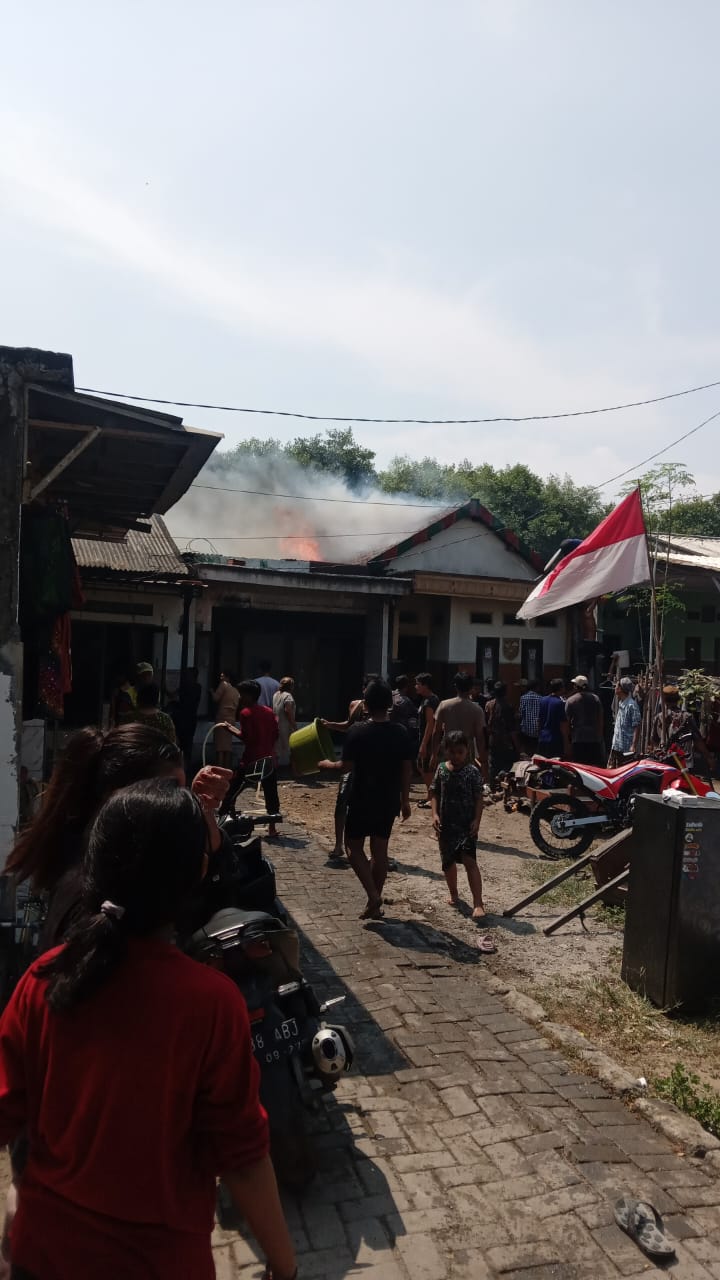 GOTONG ROYONG : Warga saat memadamkan api yang membakar dua rumah di Jalan Tambak Osowilangun X, Surabaya, Jumat (8/8).(IST/RADAR SURABAYA)
