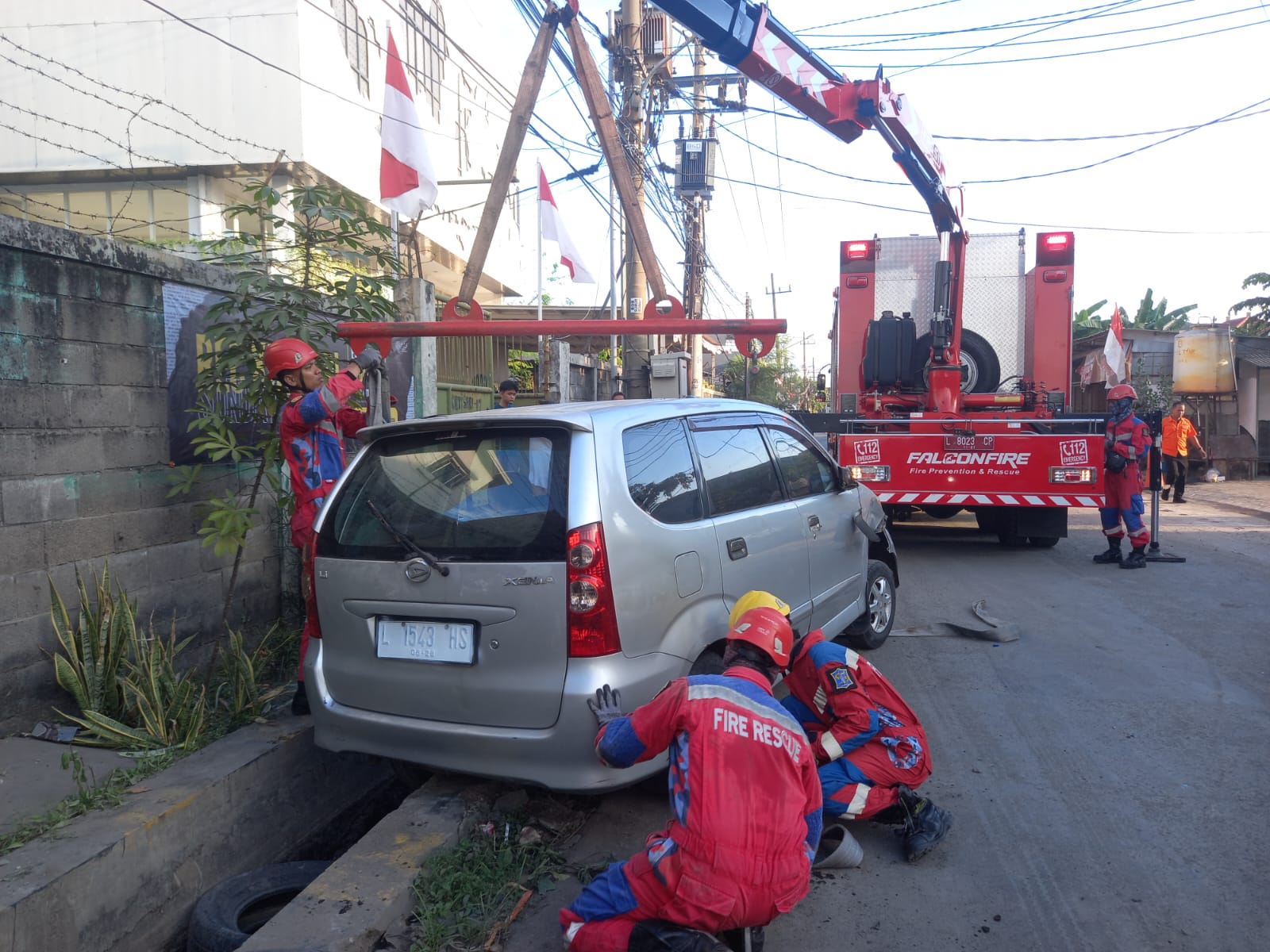 MIRING : Kondisi mobil Xenia milik SHS terperosok saluran air Jalan Kutisari Utara, Surabaya, Sabtu (9/8).(IST/RADAR SURABAYA)