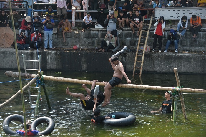 SERU: Peserta lomba kepruk guling saling menjatuhkan untuk menang. Lomba tersebut diadakan oleh Karang Taruna RW 3 Jogoloyo, Surabaya, untuk memeriahkan peringatan HUT ke-80 Kemerdekaan RI